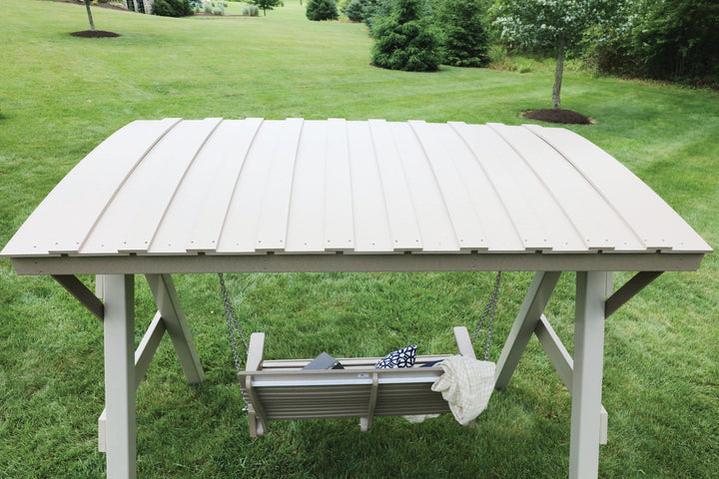 White wooden table with a swing attached on a grassy outdoor area